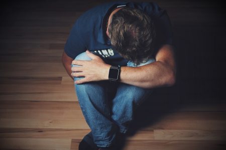 man depressed sitting on the floor