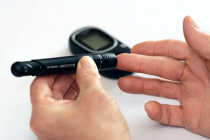A person using a lancet to check the blood sugar level