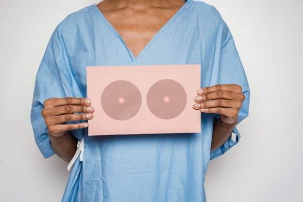 Female patient consulting plastic surgeon about breast augmentation options and implant choices in a clinical setting.