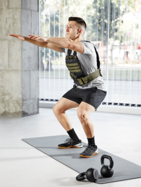 Person working out outdoors wearing a weighted vest for fitness training and endurance exercise.